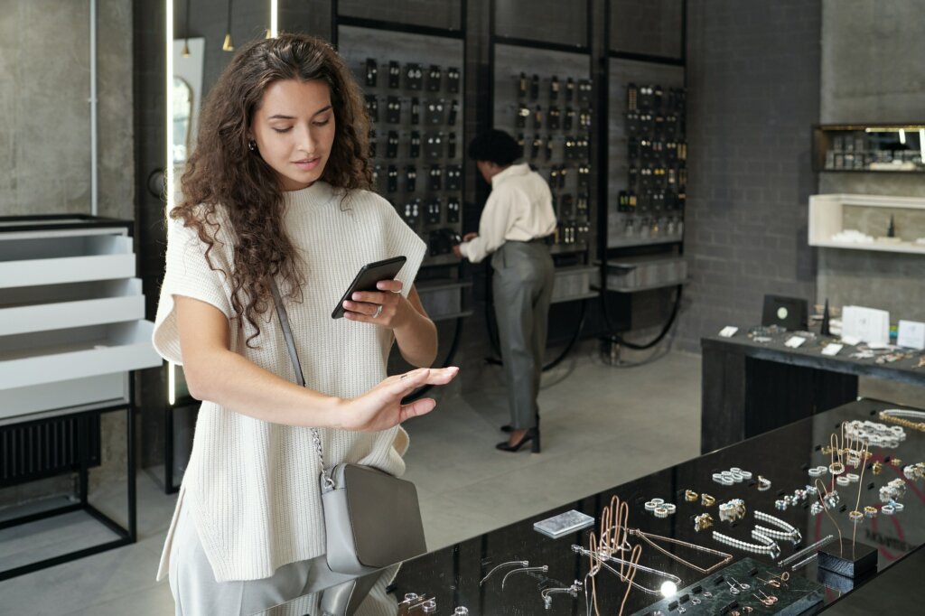 Young brunette female consumer choosing ring in jewelry shop